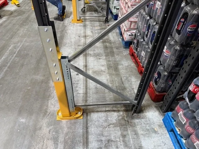Reconfigured warehouse rack upright with reinforcement